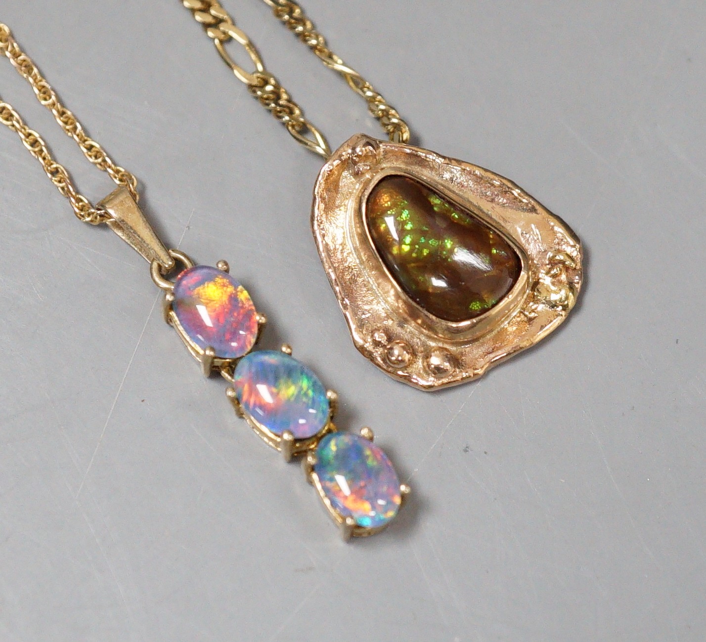 Two modern 9ct and opal set pendants, on 9ct gold chains, gross weight 10.6 grams.